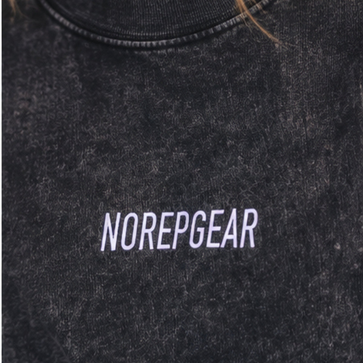 Close-up of a person wearing a dark washed crewneck sweatshirt with 'NOREPGEAR' printed in white across the chest.