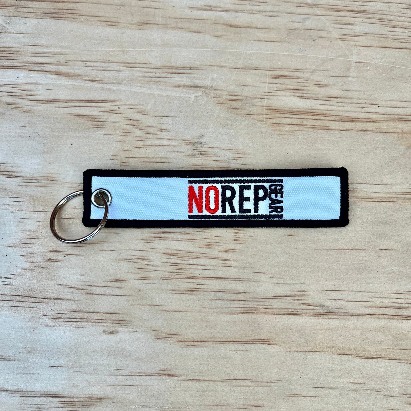 White keychain with 'NO REP GEAR' branding