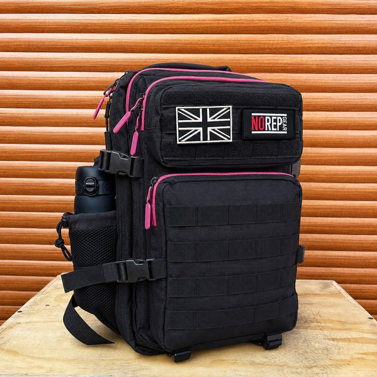 Black tactical backpack with pink zippers, used for crossfit and gym goers