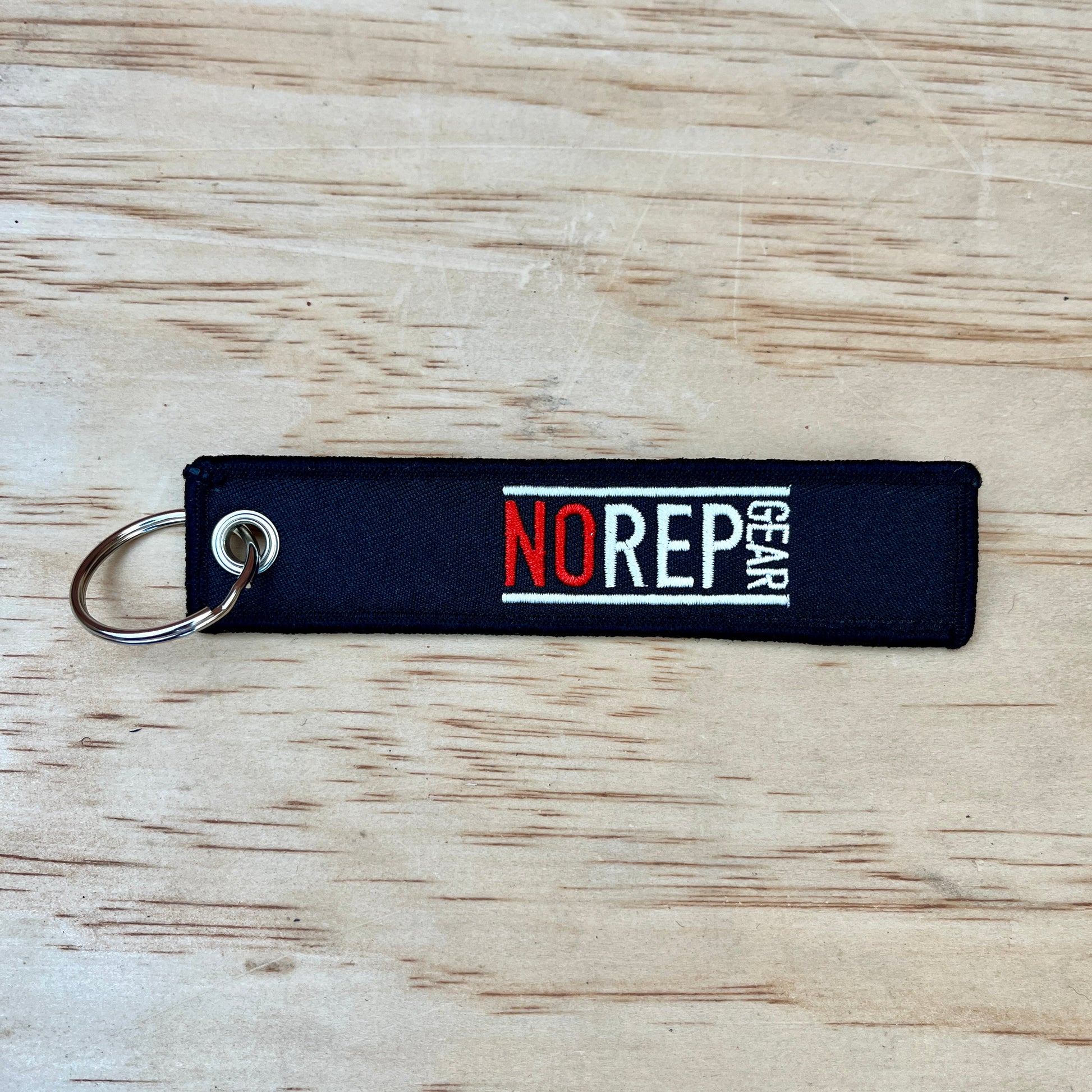 Black keychain with 'NO REP GEAR' branding 