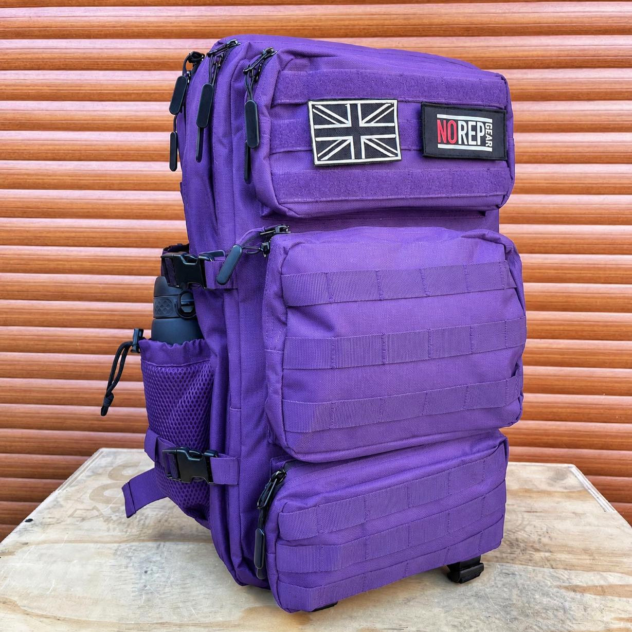 Purple tactical backpack with British flag and 'NOREPGEAR' patches